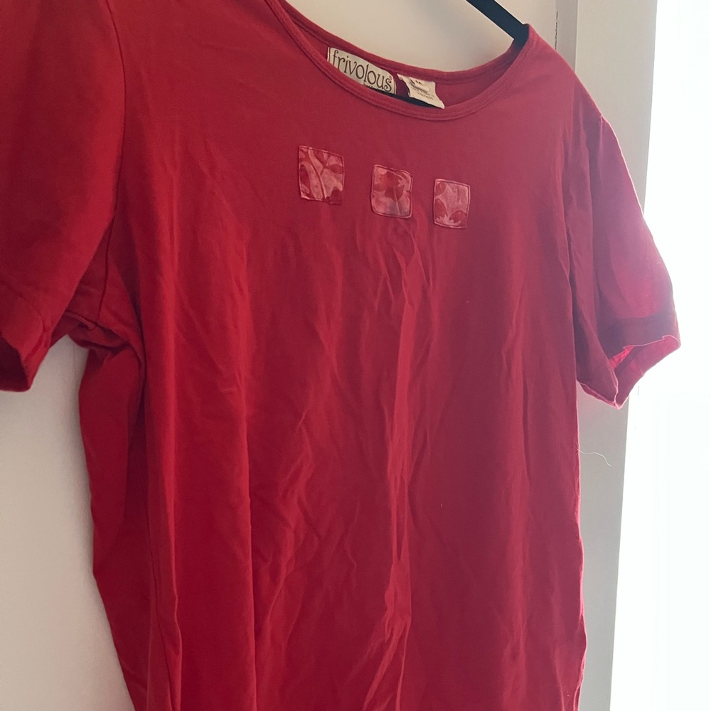 Red short sleeve top with design patches.